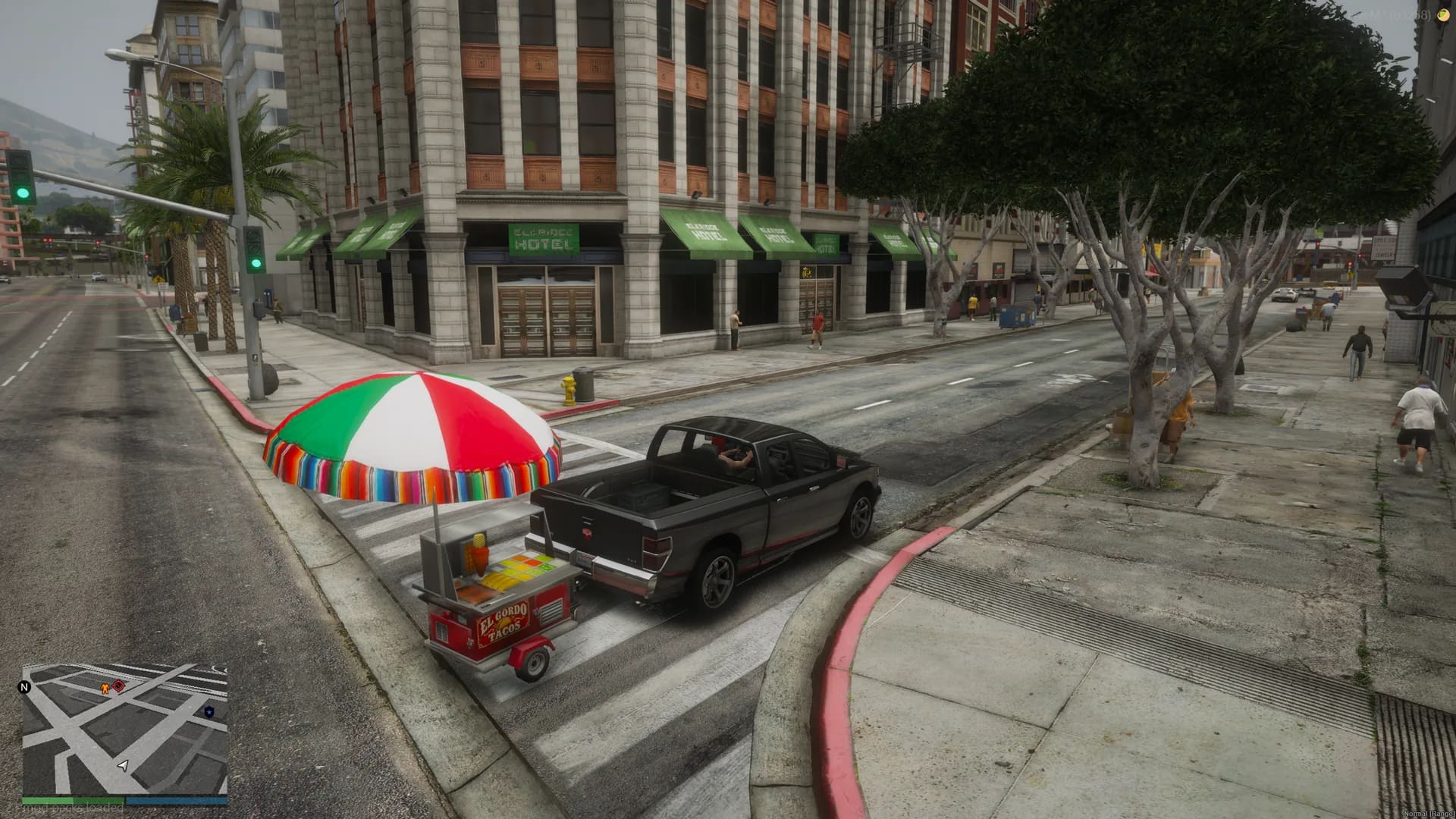 Taco cart hitched behind a pickup truck on a downtown street